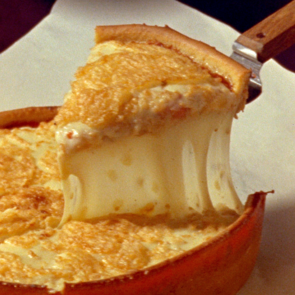 Detroit-style deep dish slice with dramatic cheese pull